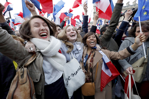 Supporters of French presidential election candidate for the En Marche! movement Emmanuel Macron celebrate in front of the Pyramid at the Louvre Museum in Paris on May 7, 2017, following the announcement of the results of the second round of the French presidential election. Emmanuel Macron was elected French president on May 7, 2017 in a resounding victory over far-right Front National (FN - National Front) rival after a deeply divisive campaign, initial estimates showed. / AFP PHOTO / Patrick KOVARIK