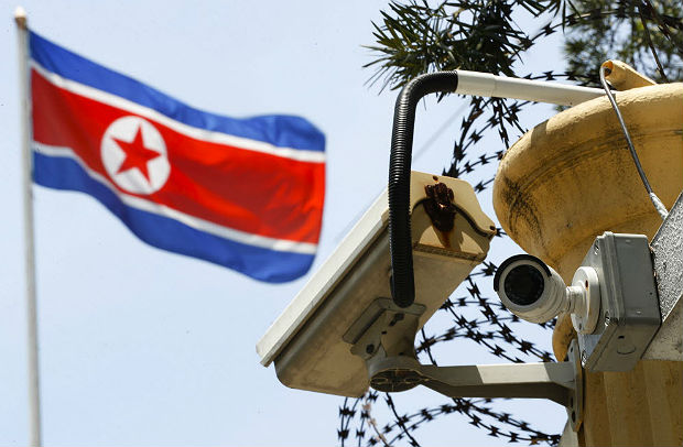 FILE - In this March 13, 2017 file photo, a CCTV surveillance camera attached by the entrance gate at the North Korean Embassy monitors passersby in Kuala Lumpur, Malaysia. In the paranoid universe of North Korea, the feverish accusations it makes against its sworn enemies bear a creepy resemblance to its own misdeeds. Its latest claim of a South Korean and American plot to assassinate Kim Jong Un using biochemical weapons comes weeks after the North Korean leader's estranged brother, Kim Jong Nam, was slain in a Malaysian airport. Authorities cited the presence of VX nerve agent, and North Korea is widely believed to have been behind responsible. (AP Photo/Vincent Thian, File) ORG XMIT: TKHO103