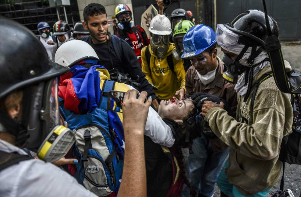 Manifestantes encapuzados tiram ferido em confronto durante protesto contra Maduro em Caracas