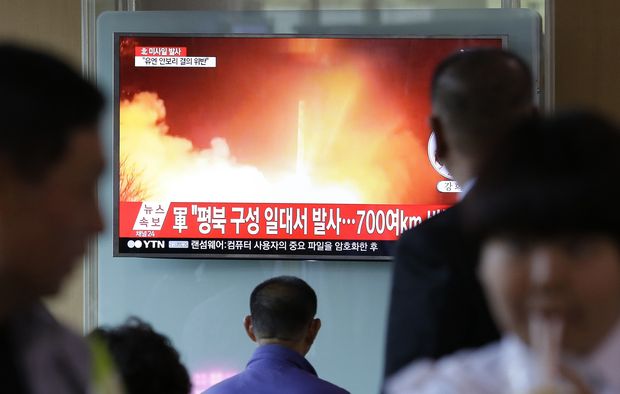 People watch a TV news program showing a file image of a missile launch conducted by North Korea, at the Seoul Railway Station in Seoul, South Korea, Sunday, May 14, 2017. North Korea on Sunday test-launched a ballistic missile that landed in the Sea of Japan, the South Korean, Japanese and U.S. militaries said. The launch is a direct challenge to the new South Korean president elected four days ago and comes as U.S., Japanese and European navies gather for joint war games in the Pacific. The signs read: 