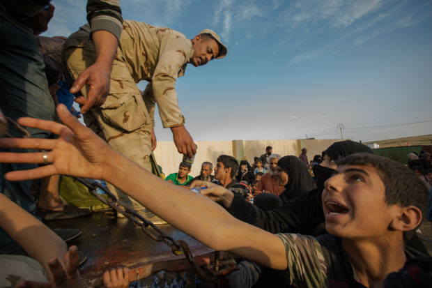 Civis chegam a entreposto de recolhimento de refugiados na parte Leste de Mosul, onde ha distribuio de gua e comida. O local esta a menos de 2 km da frente de batalha e tem recebido uma mdia de 5.000 pessoas diariamente