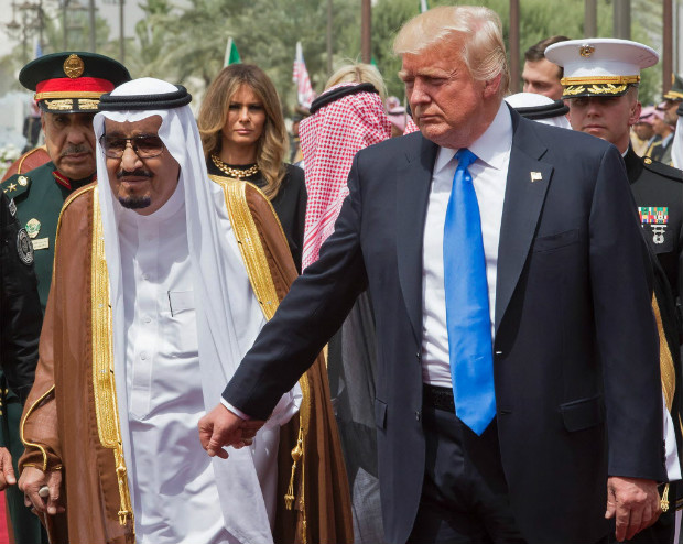 A handout picture provided by the Saudi Royal Palace on May 20, 2017, shows US President Donald Trump (R) holding the hand of Saudi Arabia's King Salman bin Abdulaziz al-Saud (L), as First Lady Melania Trump (background-C) looks on, as they arrive for a welcoming ceremony at the Saudi Royal Court in Riyadh. / AFP PHOTO / Saudi Royal Palace / BANDAR AL-JALOUD / RESTRICTED TO EDITORIAL USE - MANDATORY CREDIT "AFP PHOTO / SAUDI ROYAL PALACE / BANDAR AL-JALOUD" - NO MARKETING - NO ADVERTISING CAMPAIGNS - DISTRIBUTED AS A SERVICE TO CLIENTS