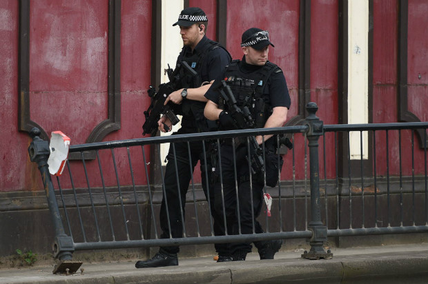 Policiais armados patrulham o entorno da estao Victoria, em Manchester, aps o atentado na cidade