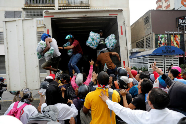 Manifestantes saqueiam produtos de limpeza de um caminho durante protesto opositor em Caracas