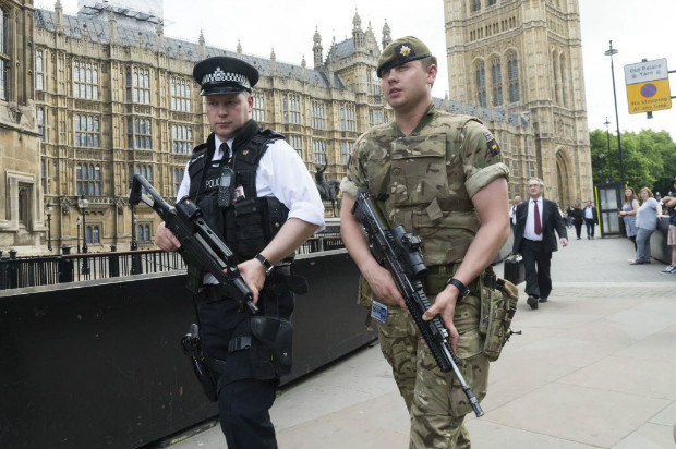 Policial e soldado patrulham o palcio de Westminster; recrutamento de policiais armados atrasa