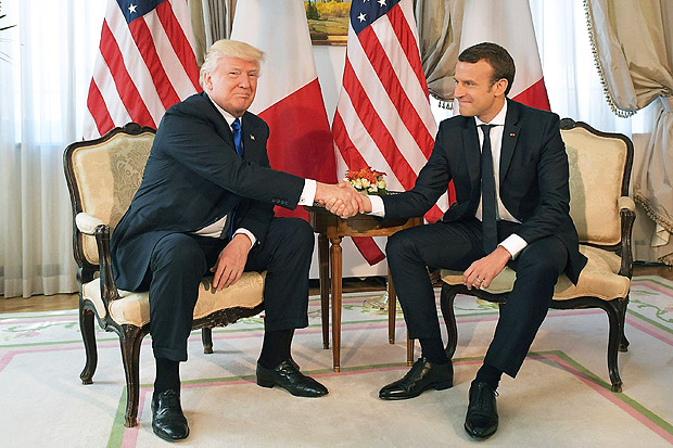 Donald Trump (esq.) e Emmanuel Macron (dir.) se cumprimentam durante encontro da Otan