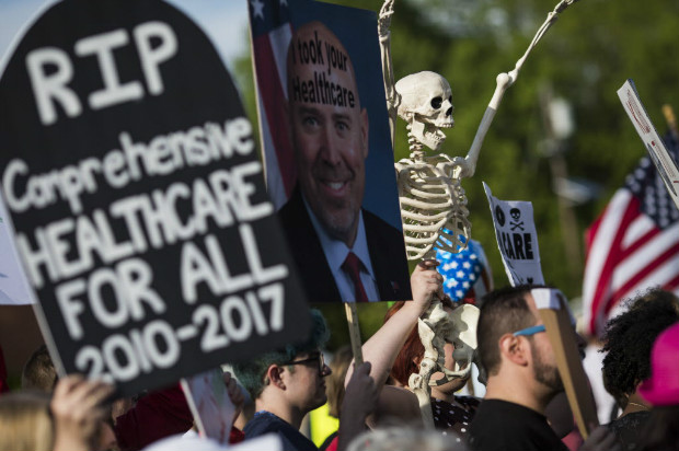 Demonstrators protest before a town hall meeting with US Representative Tom MacArthur (R-NJ) in Willingboro, New Jersey on May 10, 2017. MacArthur wrote the amendment to the American Health Care Act that revived the failed bill, delivering a legislative victory for US President Donald Trump. / AFP PHOTO / DOMINICK REUTER ORG XMIT: DRX0