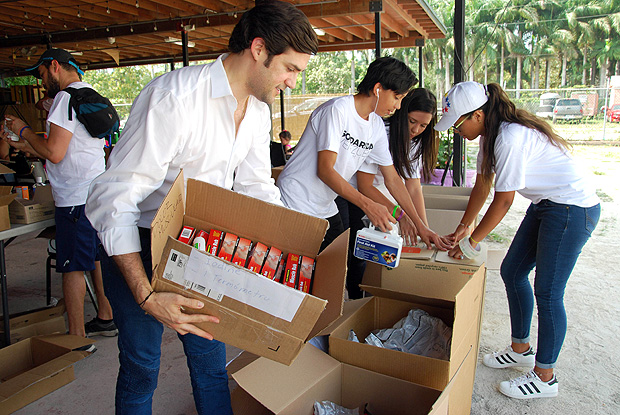 Alfred Santamaria packs medical supplies to send to protesters in Venezuela at the "Solidaridad Venezuela" event in Hialeah, Florida on May 13, 2017. Venezuela is mired in an economic crisis that has caused shortages of food, medicine and other basics in the oil-rich country. A total of 38 people have died in street unrest since protests first broke out on April 1. Hundreds more have been injured. / AFP PHOTO / Jose Caruci