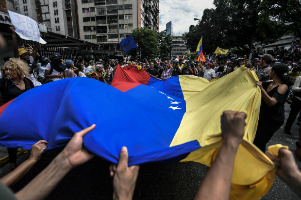 Manifestantes contra o presidente Nicols Maduro agitam bandeira da Venezuela em ato em Caracas