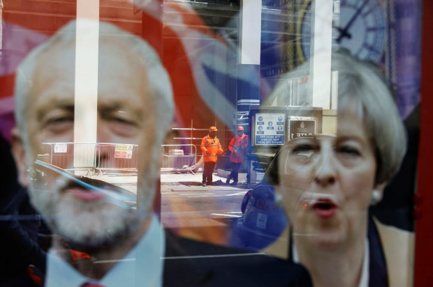 Cartazes em loja de apostas mostram a primeira-ministra, Theresa May, e o trabalhista Jeremy Corbyn