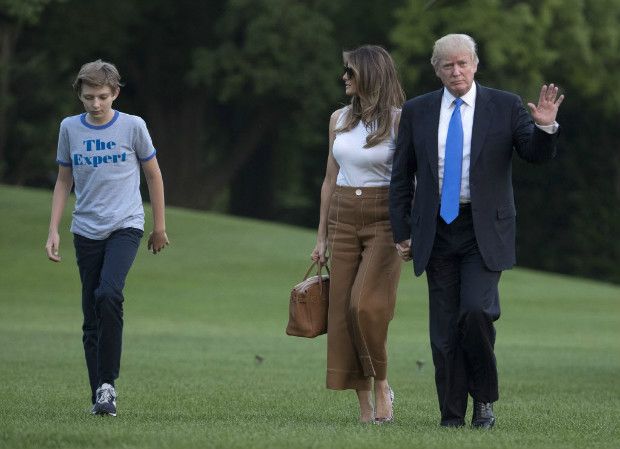 O presidente dos EUA, Donald Trump, chega com a mulher, Melania, e o filho, Barron,  Casa Branca