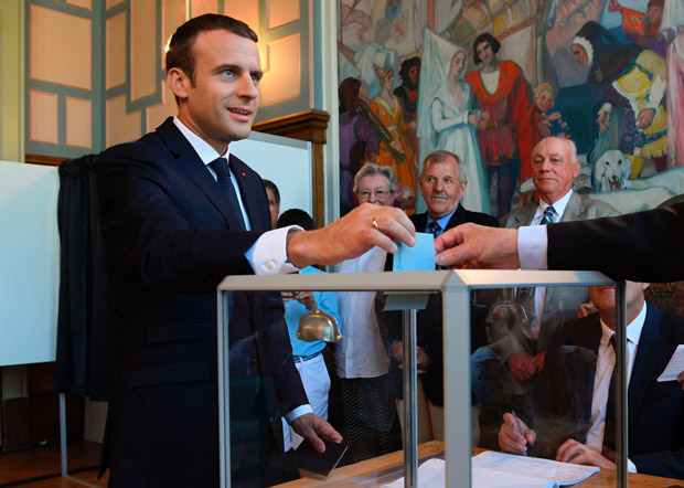 French President Emmanuel Macron casts his ballot as he votes at a polling station in Le Touquet, northern France, during the second round of the French parliamentary elections (elections legislatives in French), on June 18, 2017. / AFP PHOTO / POOL AND AFP PHOTO / CHRISTOPHE ARCHAMBAULT
