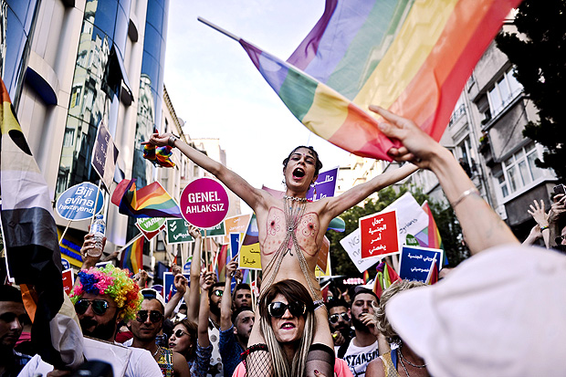 People shout slogans and wave rainbow flags during the Gay Pride parade on June 28, 2015 in the Cihangir neighborhood near the Taksim square in Istanbul. Riot police in Istanbul used tear gas and water cannon to disperse thousands of participants in the Gay Pride parade in the Turkish city, an AFP reporter said. Police took action against the crowd when demonstrators began shouting slogans accusing the social conservative President Recep Tayyip Erdogan of "fascism". AFP PHOTO/OZAN KOSE ORG XMIT: 2248