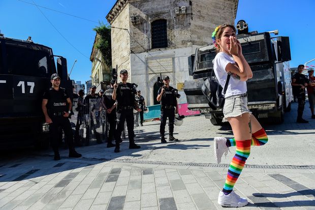Turkish riot police officers block ways to Istikjlal avenue for LGBT rights activist (C) as they try to gather for a pride parade, which was banned by the governorship, in central Istanbul, on June 25, 2017. / AFP PHOTO / BULENT KILIC