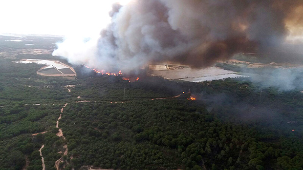 In this image supplied by INFOCA and taken Saturday June 24, 2017, a forest fire blazes in the Moguer area in southern Spain. A forest fire in southern Spain has forced the evacuation of 1,000 people and is threatening Donana National Park, one of Spain's most important nature reserves and a UNESCO World Heritage site since 1994, and famous for its biodiversity, authorities said Sunday. (INFOCA via AP) ORG XMIT: PW101