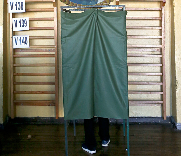 A man stands inside a polling booth during the primary election for the conservative coalition of parties called 