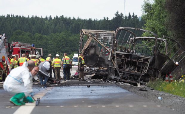 Autoridades trabalham em local de acidente que deixou nibus totalmente queimado na Alemanha