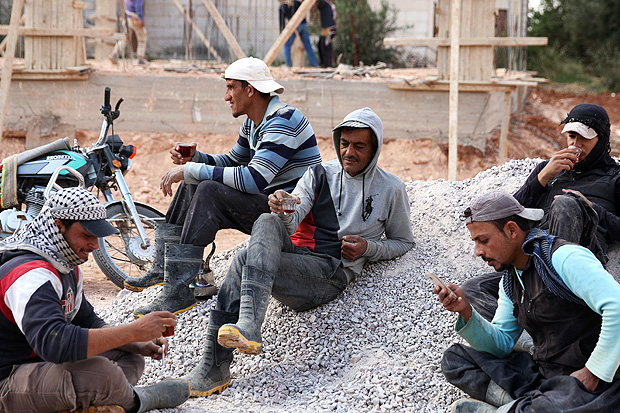 Abu Salem, a builder and head of "You Destroy and We Rebuild Brigade" consisting of a 12 construction workers, drinks tea with his coworkers at a construction site, in the rebel-held town of Saida, in Deraa province, Syria May 24, 2017. Picture taken May 24, 2017. REUTERS/Alaa Al-Faqir ORG XMIT: HFS-SYR01