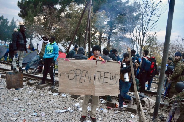 Homem segura placa com os dizeres "Abram o Caminho" no campo de refugiados de Idomeni