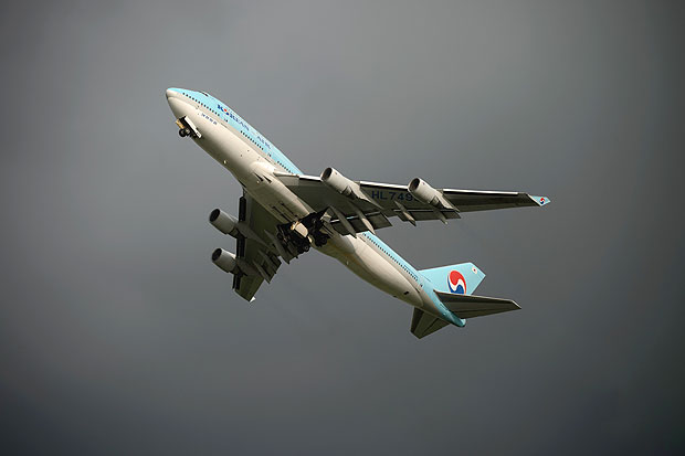 In a photo taken on August 26, 2014 a Korean Air Boeing 747 aircraft takes off before storm clouds at Gimpo airport, south of Seoul. South Korea's international air passenger traffic grew more than 10 percent in July from a year earlier with the number of international air passengers to and from South Korea at 5.13 million, up 10.6 percent from the previous year, according to the Ministry of Land, Infrastructure and Transport. AFP PHOTO / Ed Jones ORG XMIT: EJJ3163