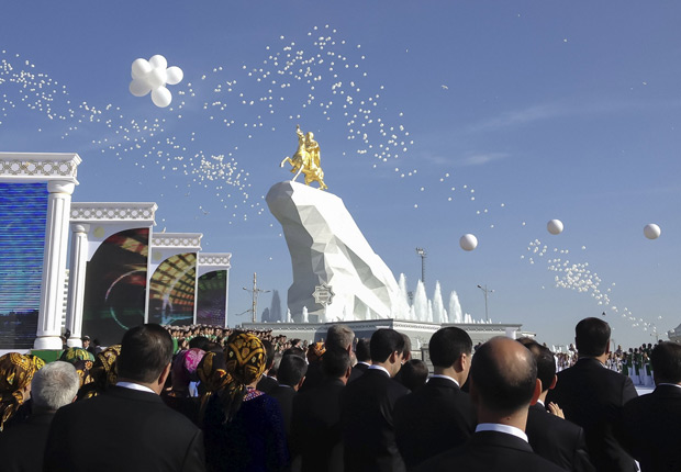 People gather in front of a monument to Turkmenistan's President Kurbanguly Berdymukhamedov during its inauguration ceremony in Ashgabat, Turkmenistan, May 25, 2015. Turkmenistan unveiled the first monument to Berdymukhamedov on Monday - a gilded 6-meter-high statue of the leader on horseback perched on a white cliff, reflecting his flourishing personality cult in the reclusive gas-rich nation. REUTERS/Marat Gurt TPX IMAGES OF THE DAY ORG XMIT: MOS02LEGENDA DO JORNALCULTO  PERSONALIDADE Inaugurao de esttua do presidente do Turcomenisto, Kurbanguly Berdymukhamedov, em Ashgabat; monumento tem seis metros de altura
