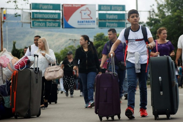 Venezuelanos carregam malas na ponte que liga San Antonio del Tchira e  colombiana Ccuta