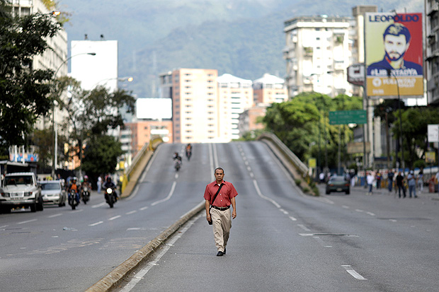 A pedestrian walks along a street during a strike called to protest against Venezuelan President Nicolas Maduro's government in Caracas, Venezuela July 26, 2017. REUTERS/Ueslei Marcelino ORG XMIT: IA123