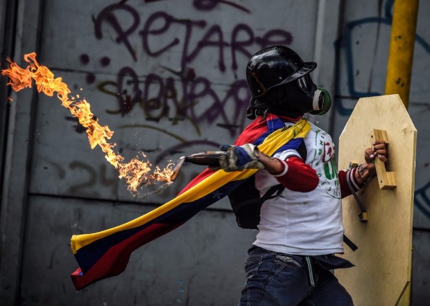 Manifestante mascarado contra Nicols Maduro atira coquetel molotov em confronto com guardas