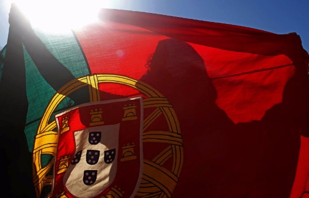A Portugal fan holds the country's national flag during a World Cup soccer match against Ghana 