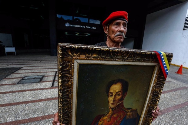 Aliado de Nicols Maduro segura retrato de Simn Bolvar em ato de apoio ao presidente em 2 de junho