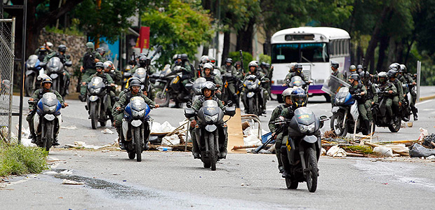 Members of the National Guard ride motorcycles past an opposition barricade as the Constituent Assembly election was being carried out in Caracas, Venezuela, July 30, 2017. REUTERS/Christian Veron ORG XMIT: CCS650