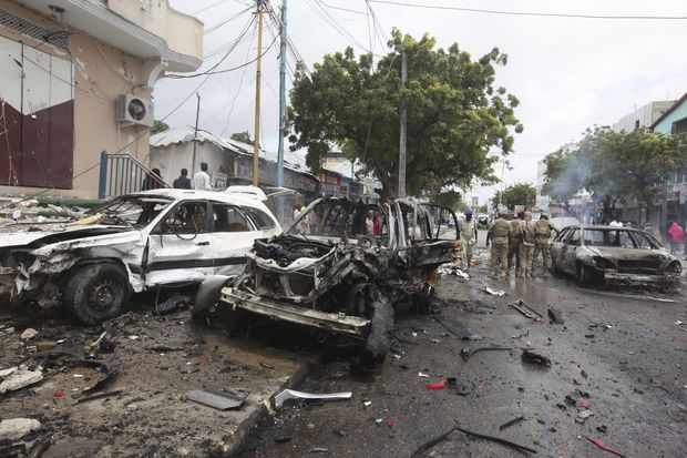 Somali soldiers check destroyed cars near a popular mall, after a car bomb attack in Mogadishu, Somalia, Sunday, July 30, 2017. A police officer says a car bomb blast near a police station in Somalia's capital has killed at least five people and wounded at least 13 others. Most of the victims are civilians. The Somalia-based extremist group al-Shabab often carries out deadly bombings in Mogadishu. (AP Photo/Farah Abdi Warsameh) ORG XMIT: AAS114