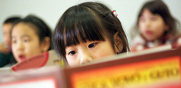 ORG XMIT: 450301_1.tif Criana imigrante brasileira (nissei) estuda no Colgio Pitgoras, em Ota, Japo, onde as aulas so em portugus e o japons  uma das disciplinas. Gabriela Yukari, a primary school student reads a Portuguese language book during class at the Colegio Pitagoras Brazilian School in Ota, Japan, Nov. 18,1999. Yukari is unable to read Japanese, and speaks only a few words of Japanese. All classes at the school are in Portuguese with Japanese being one of the subjects taught. Hundreds of thousands of Brazilians, most of them of Japanese descent, have poured into the country in the past decade with short-term plans, only to end up staying for years. (AP Photo/David Guttenfelder) 