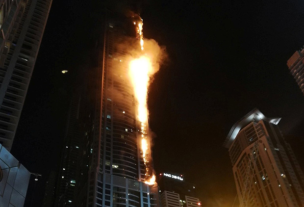 Flames shoot up the sides of the Torch tower residential building in the Marina district, Dubai, United Arab Emirates, in this August 4, 2017 picture by Mitch Williams. Mitch Williams/Social Media Website/via REUTERS ATTENTION EDITORS - THIS IMAGE WAS PROVIDED BY A THIRD PARTY. NO ARCHIVES. NO RESALES. MANDATORY ON-SCREEN CREDIT: Mitch Williams / @MitchGWilliams THIS PICTURE WAS PROCESSED BY REUTERS TO ENHANCE QUALITY. AN UNPROCESSED VERSION HAS BEEN PROVIDED SEPARATELY. ORG XMIT: SIN902R