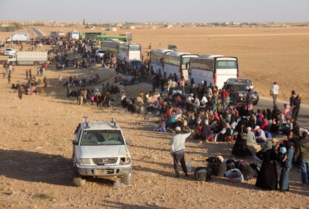 Milhares de civis srios e militantes de uma filial da Al Qaeda fazem fila para serem levados a Idlib