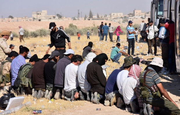 Militantes da filial sria da Al Qaeda e civis oram antes de comear a viagem at a provncia de Idlib