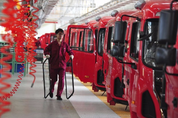 Funcionário carrega vidros para caminhões em linha de montagem de fábrica em Fuyang, na China