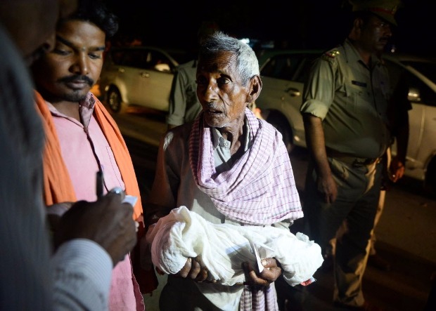 Parente carrega beb morto por falta de oxignio no hospital Baba Raghav Das, em Gorakhpur (ndia) 
