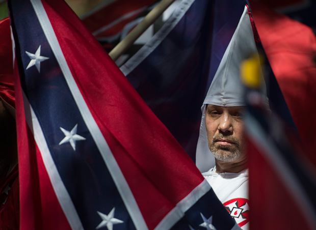 (FILES) This file photo taken on July 08, 2017 shows a member of the Ku Klux Klan during a rally, calling for the protection of Southern Confederate monuments, in Charlottesville, Virginia. A sizeable contingent of members of the extreme right and white nationalists are expected to descend on a small US university town on August 12, 2017 -- and a fierce opposition front is uniting against it.Thousands of white nationalists, including supporters of the Ku Klux Klan white supremacist group, and anti-fascist activists are expected to clash in Charlottesville, Virginia, a sleepy town planning to remove a statue of General Robert E. Lee, who led Confederate forces in the US Civil War. / AFP PHOTO / ANDREW CABALLERO-REYNOLDS