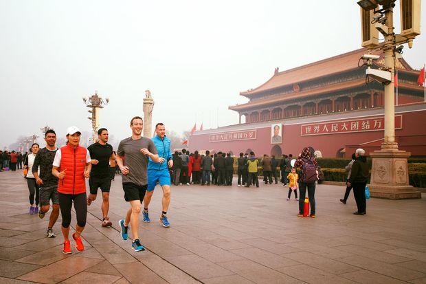 Mark Zuckerberg (de cinza) corre na praa da Paz Celestial, em Pequim, em foto de junho de 2016