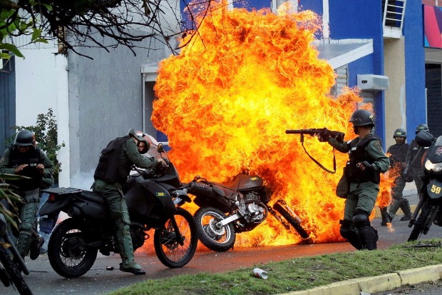 Guardas nacionais enfrentam manifestantes que queimaram moto em San Cristbal, em Tchira