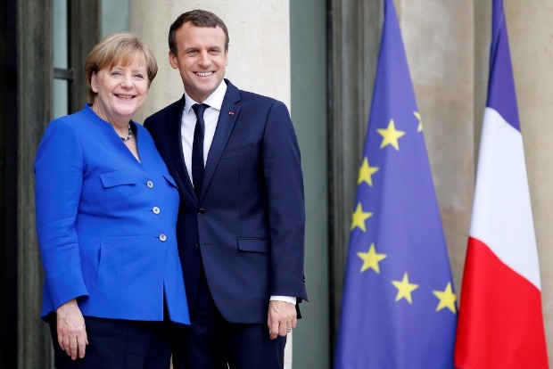 FILE PHOTO: French President Emmanuel Macron arrives with German Chancellor Angela Merkel to attend a Franco-German joint cabinet meeting at the Elysee Palace in Paris, France, July 13, 2017. REUTERS/Stephane Mahe/File Photo ORG XMIT: HFS - SAA66