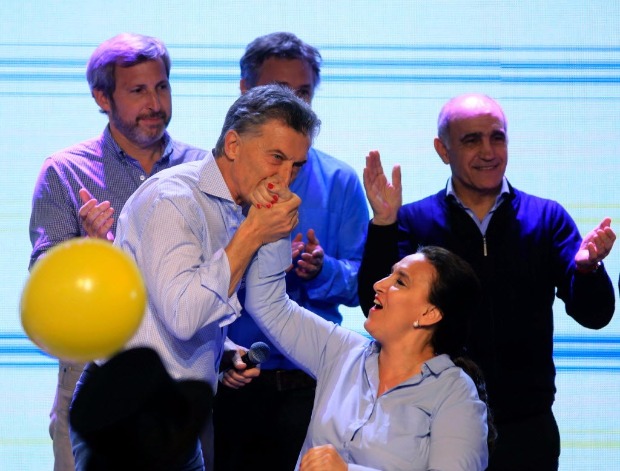 This photo released by Noticias Argentinas shows Argentinian President Mauricio Macri (C-L) kissing the hand of Argentinian Vicepresident Gabriela Michetti (C-R) during a celebration after primary legislative elections in Argentina, in Buenos Aires on August 13, 2017. / AFP PHOTO / NOTICIAS ARGENTINAS / MARCELO CAPECE / Argentina OUT