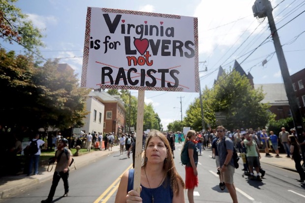 CHARLOTTESVILLE, VA - AUGUST 12: A counter-demonstrator marches down the street after the "Unite the Right" rally, a gathering of white nationalists, neo-Nazis and members of the "alt-right" was declared an unlawful gathering August 12, 2017 in Charlottesville, Virginia. After clashes with anti-fascist protesters and police the rally was declared an unlawful gathering and people were forced out of Lee Park, where a statue of Confederate General Robert E. Lee is slated to be removed. Chip Somodevilla/Getty Images/AFP == FOR NEWSPAPERS, INTERNET, TELCOS & TELEVISION USE ONLY ==