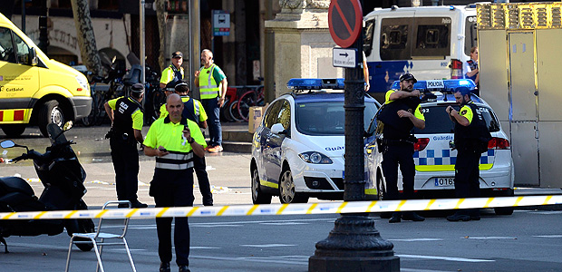 Medical staff members and policemen stand in a cordoned off area after a van ploughed into the crowd, injuring several persons on the Rambla in Barcelona on August 17, 2017. Police in Barcelona said they were dealing with a "terrorist attack" after a vehicle ploughed into a crowd of pedestrians on the city's famous Las Ramblas boulevard on August 17, 2017. Police were clearing the area after the incident, which has left a number of people injured. / AFP PHOTO / Josep LAGO