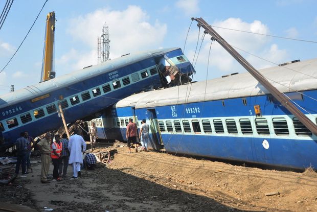 Polcia indiana e equipe de emergncia esto ao lado da escada de um vago de trem depois que um trem expresso descarrilou a noite deixando 23 mortos