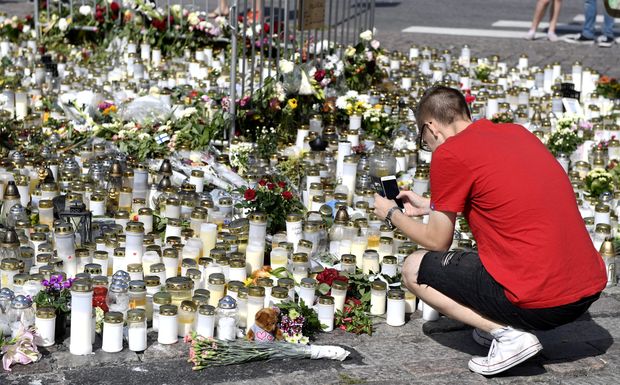 Mourners bring memorial cards, candles and flowers to the Turku Market Square, in Turku, Finland August 20, 2017.