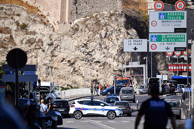 TOPSHOT - French forensic police officers and security personnel gather near a vehicle following a car crash in the southern Mediterranean city of Marseille on August 21, 2017. At least one person has died in Marseille after a car crashed into people waiting at two different bus stops in the southern French port city, police sources told AFP, adding that the suspected driver had been arrested afterwards. The police sources, who asked not to be identified, did not say whether the incident was being treated as a terror attack or an accident. / AFP PHOTO / BERTRAND LANGLOIS ORG XMIT: BL2643