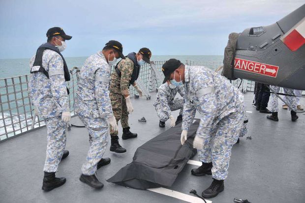In this photo released by the Royal Malaysian Navy, navy sailors cover an unidentified body on to the deck of KD Lekiu frigate after it was recovered in the waters off the Johor coast of Malaysia, Tuesday, Aug. 22, 2017. The commander of the U.S. Pacific Fleet said some remains of Navy sailors were found in a compartment of the USS John McCain on Tuesday, a day after the warship's collision with an oil tanker in Southeast Asian waters left 10 sailors missing. 