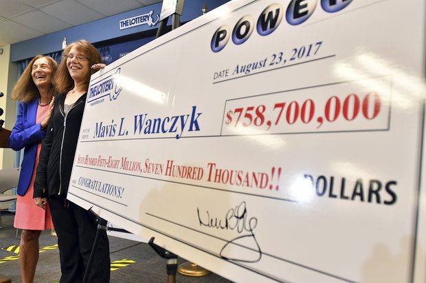 Mavis Wanczyk, of Chicopee, Mass., stands by a poster of her winnings during a news conference where she claimed the $758.7 million Powerball prize at Massachusetts State Lottery headquarters, Thursday, Aug. 24, 2017, in Braintree, Mass. Officials said it is the largest single-ticket Powerball prize in U.S. history. At left is state treasurer Deb Goldberg.